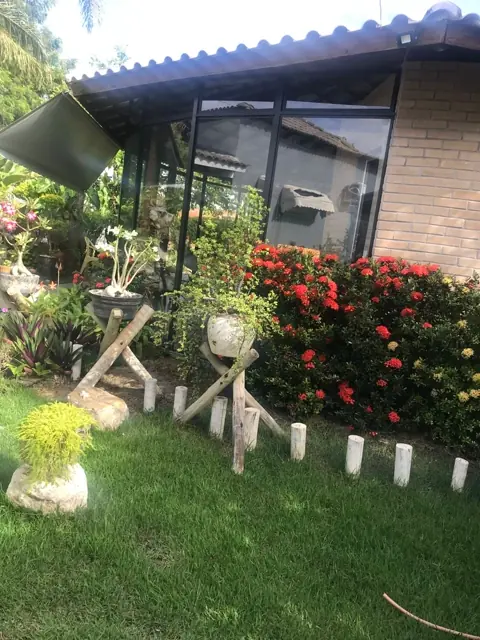 Fachada do Quarto Duplo 02 cercada por jardim florido