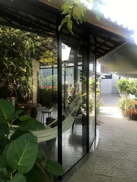 Varanda envidraçada em meio às plantas